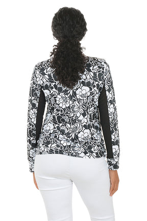 Woman wearing a black and white floral blouse with a white background. Back shot.