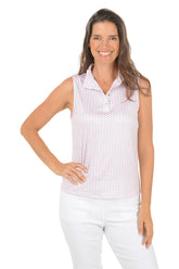 Woman wearing a sleeveless patterned top and white pants on a white background.