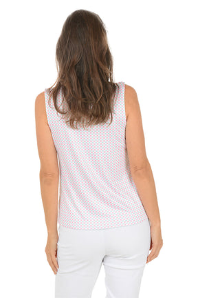 Woman wearing a sleeveless patterned top and white pants on a white background. Back shot.
