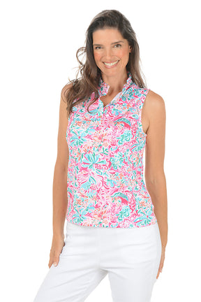 Woman wearing a colorful sleeveless floral top on a white background.