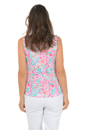 Woman wearing a colorful sleeveless floral top on a white background. Back shot.