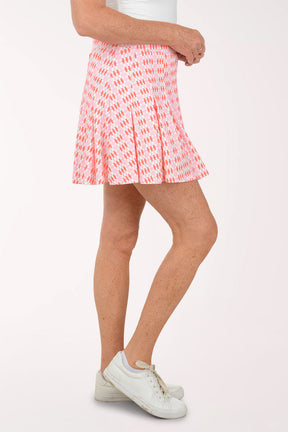 Person wearing a pink patterned skirt on a white background