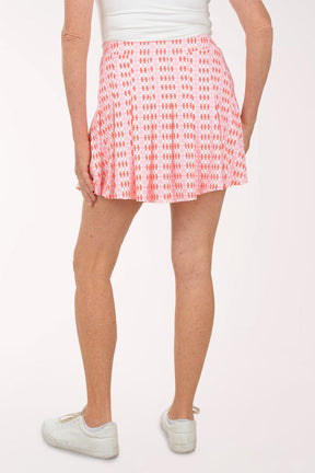 Person wearing a pink patterned skirt on a white background