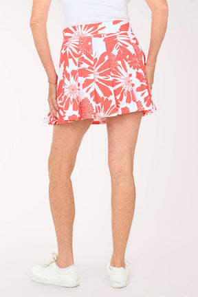 Woman wearing a coral floral pleated skirt