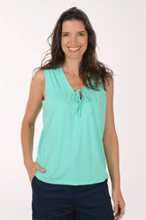 Woman wearing a light blue sleeveless top with a white background