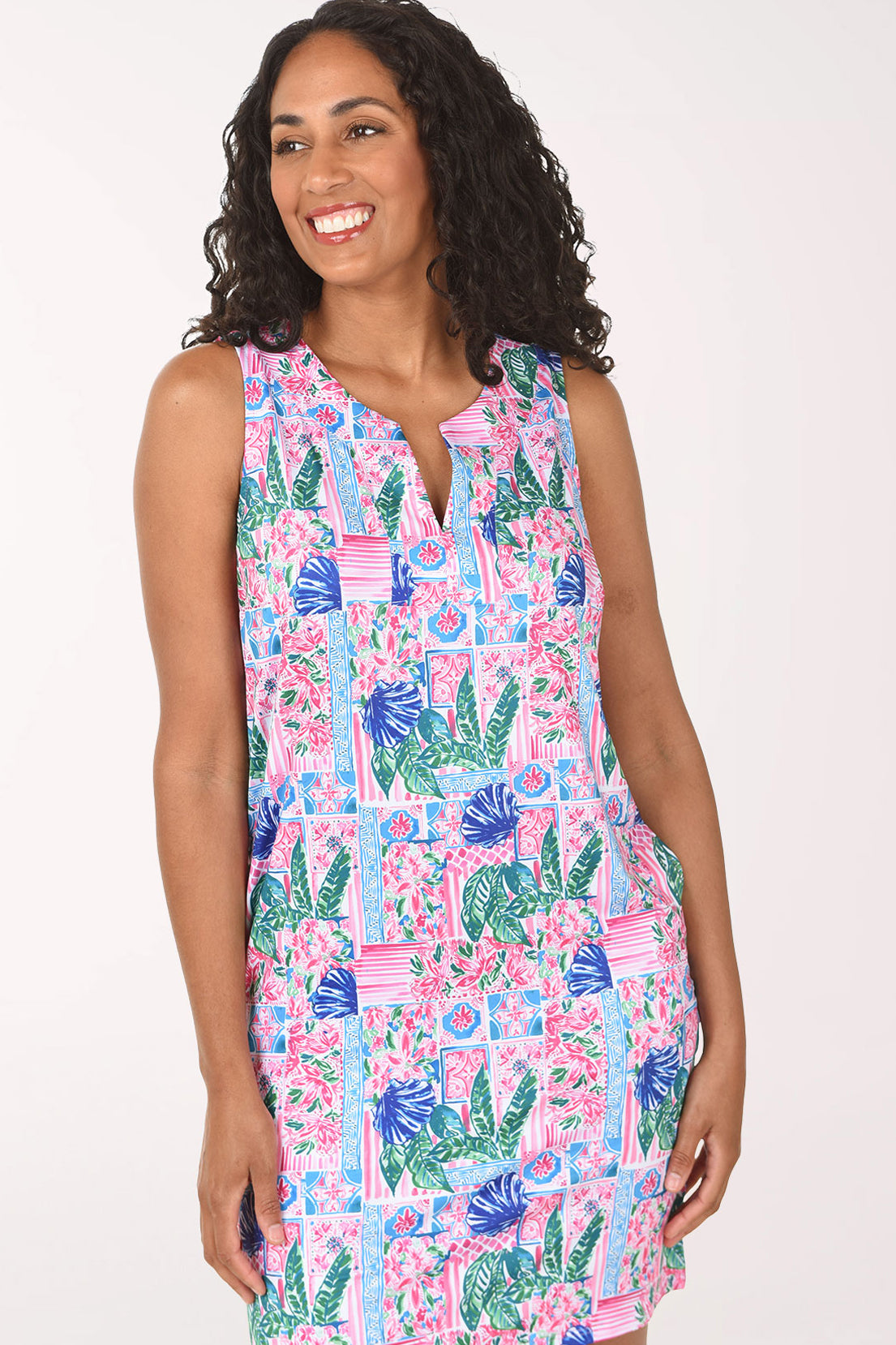 Woman wearing a colorful dress with floral and cactus pattern on a white background