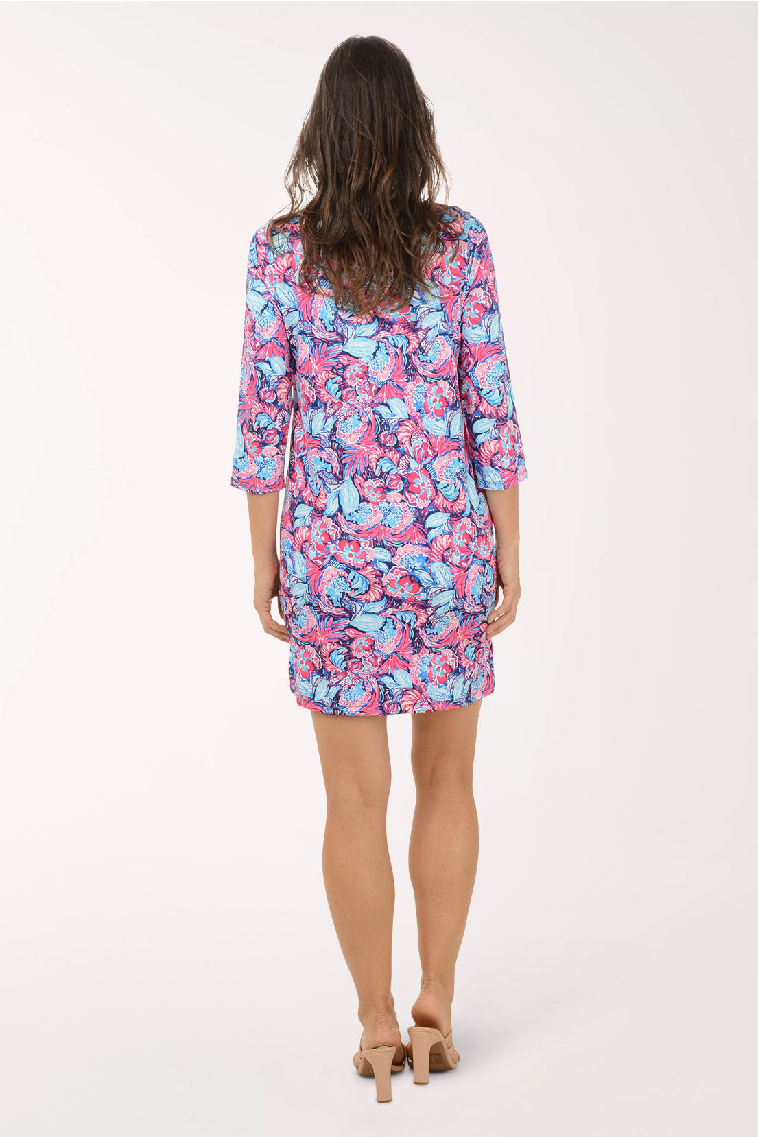 Woman wearing a colorful floral dress on a white background