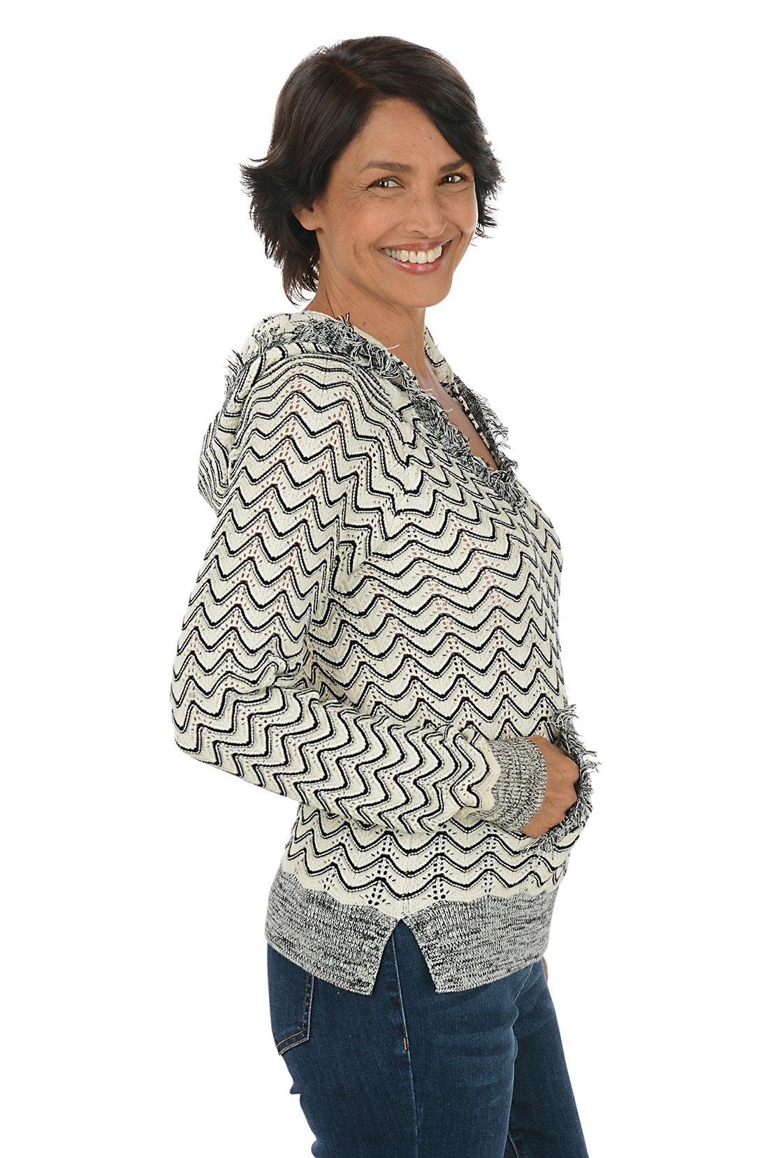 Woman wearing a zigzag patterned hoodie on a white background. Side shot.