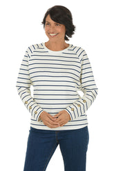 Woman wearing a white and navy striped crew neck sweater.