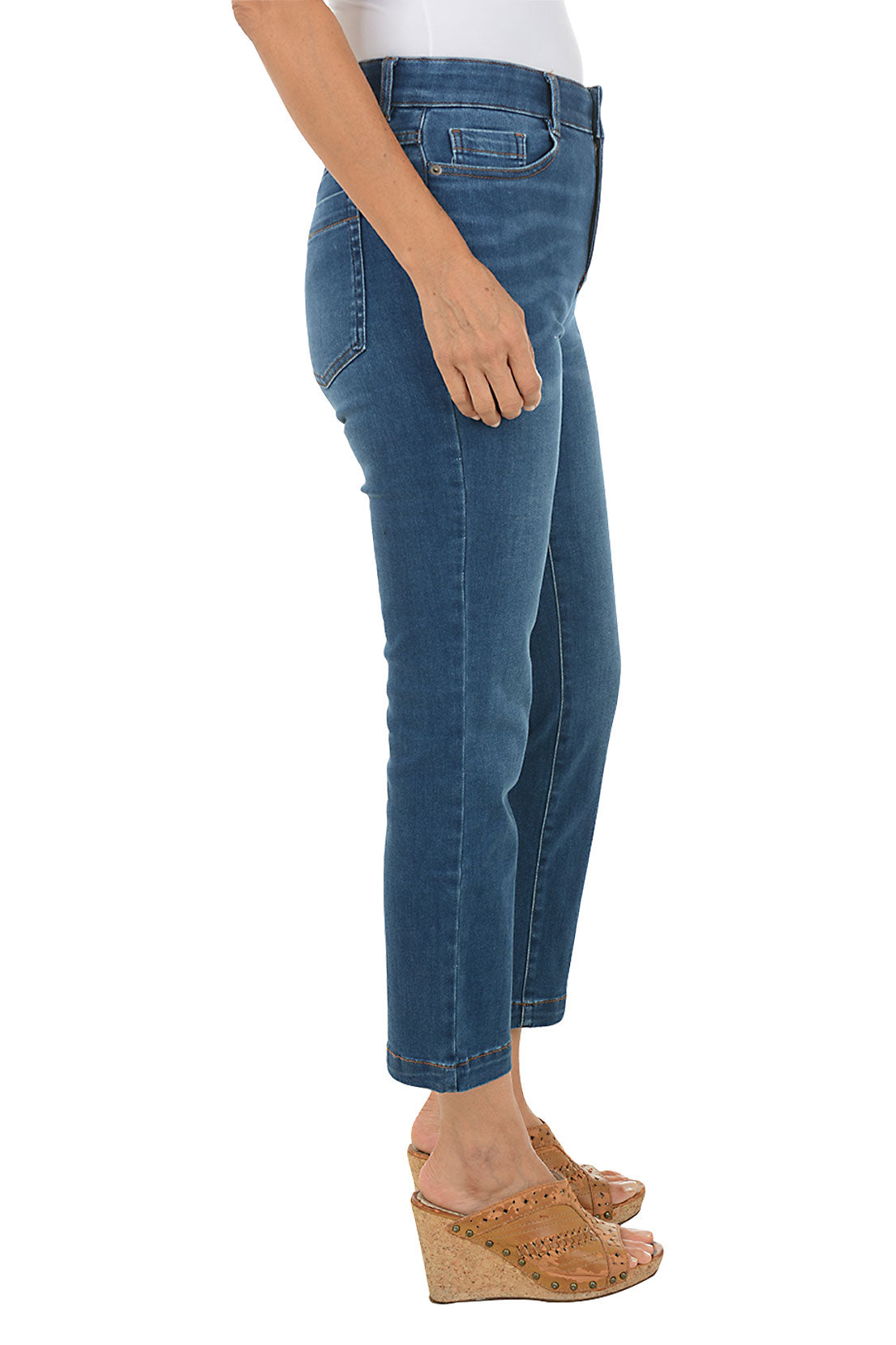 Person wearing blue jeans on a white background. Side shot.