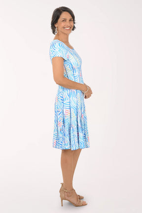 Woman wearing a blue patterned dress on a white background