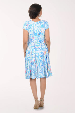 Woman wearing a blue patterned dress on a white background