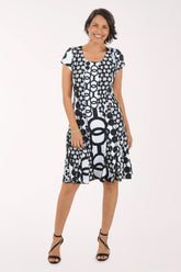Woman wearing a black and white patterned dress on a white background