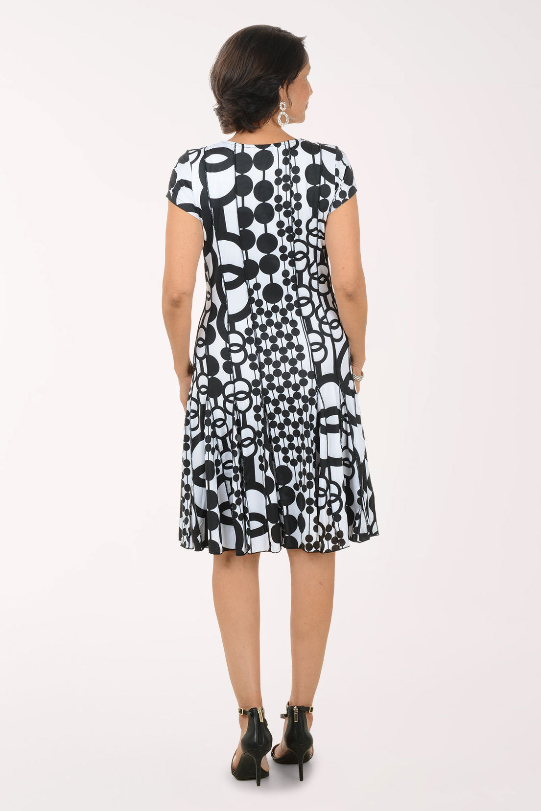 Woman wearing a black and white patterned dress on a white background