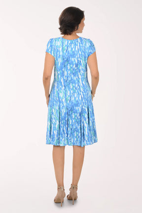 Woman wearing a blue patterned dress on a white background