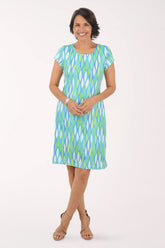 Woman wearing a green and blue patterned dress on a white background