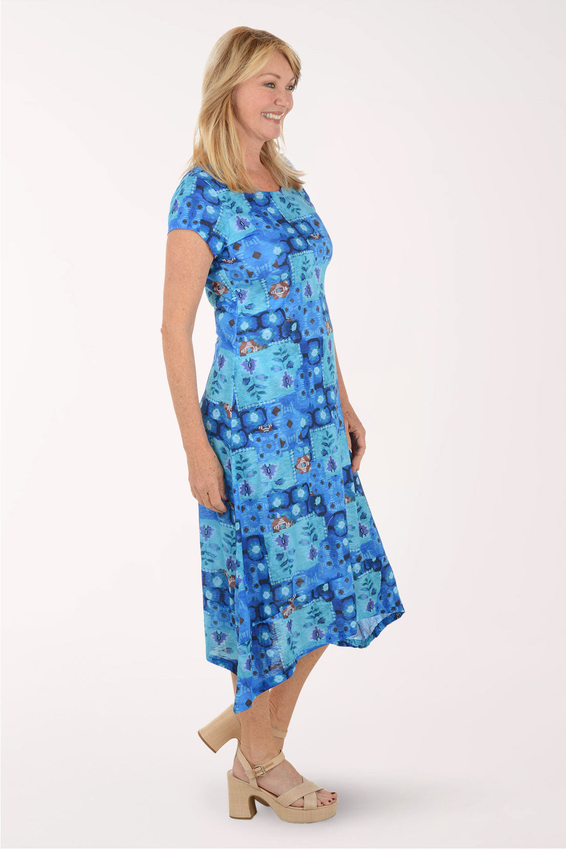 Woman wearing a blue patterned dress on a white background
