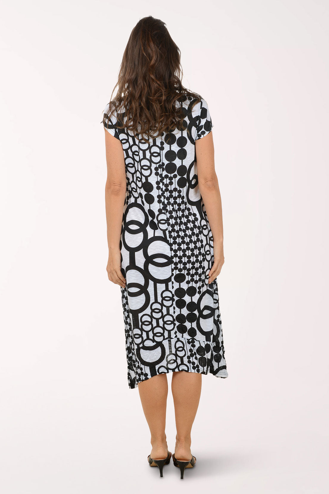 Woman wearing a black and white patterned midi dress on a white background