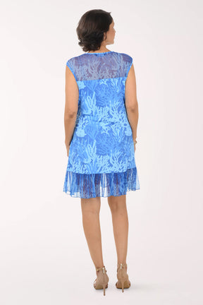 Woman wearing a blue dress with lace details on a white background