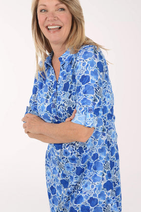 Woman wearing a blue floral dress on a white background