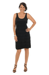Woman wearing a sleeveless black dress on a white background.