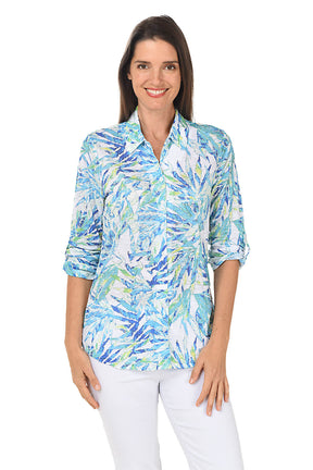 Woman wearing a colorful patterned shirt on a white background.