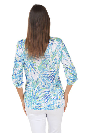 Woman wearing a colorful patterned shirt on a white background. Back shot.