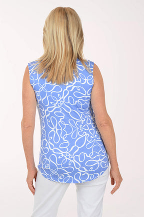 Woman wearing a blue sleeveless top with white floral pattern on a white background