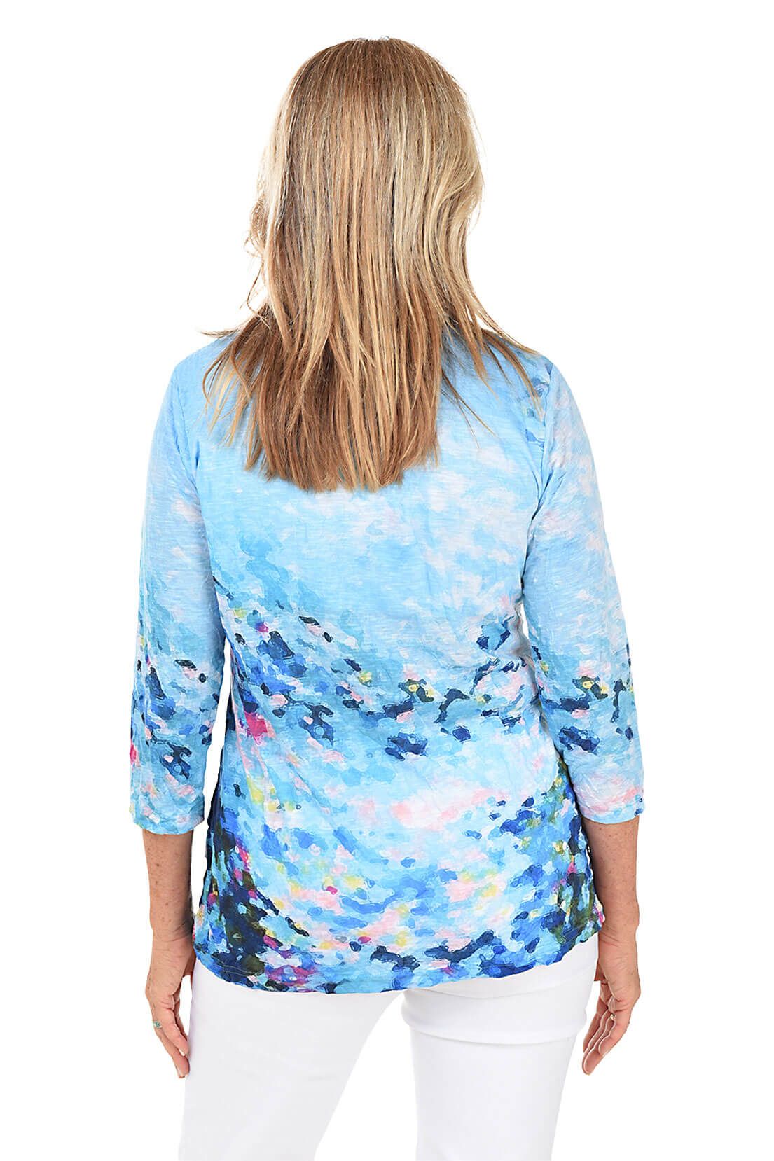 Woman wearing a blue floral long-sleeve top on a white background. Back shot.