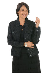Woman wearing a black patterned jacket on a white background.