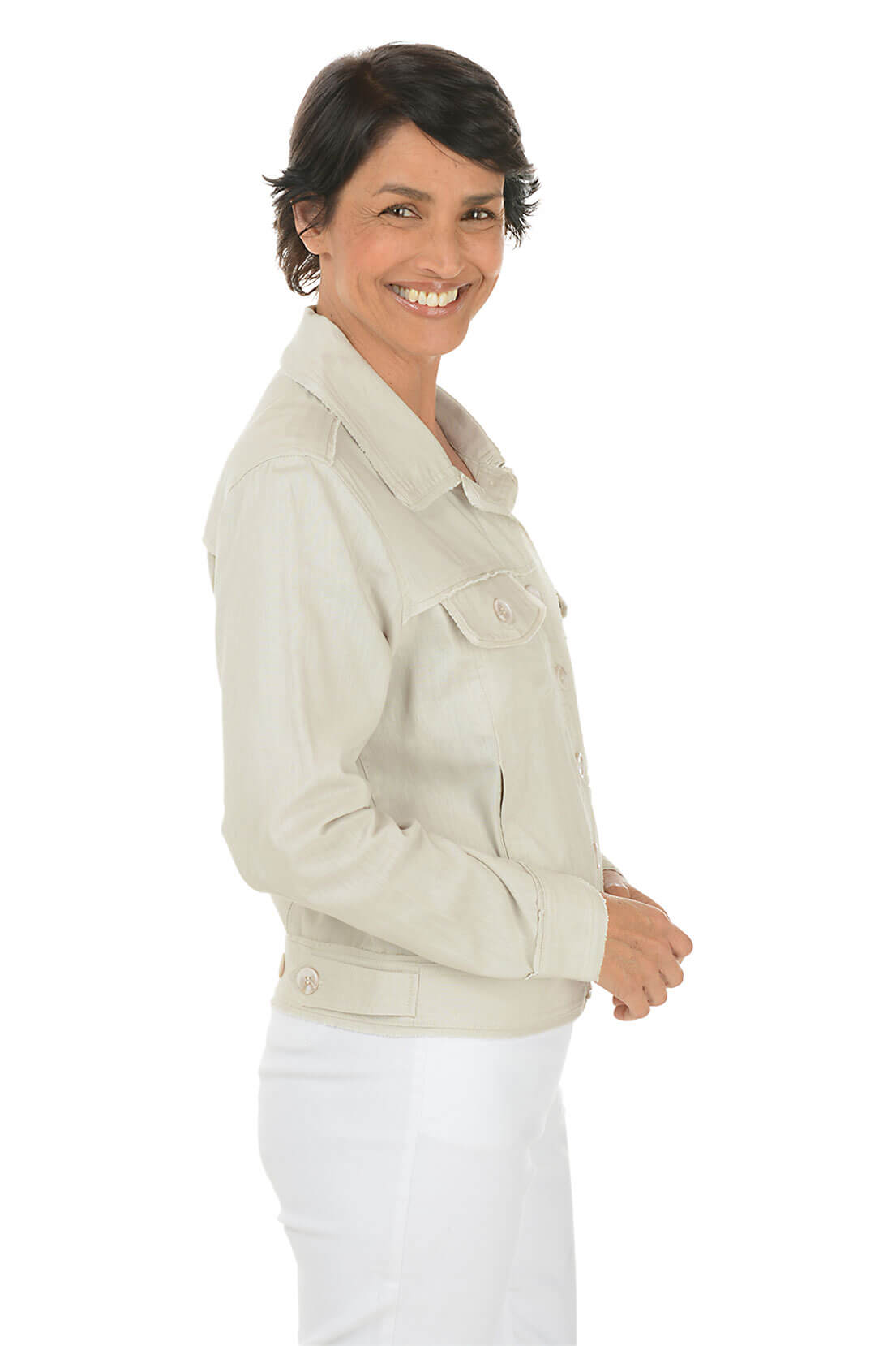 Woman wearing a light-colored jacket and white pants on a white background. Side shot.