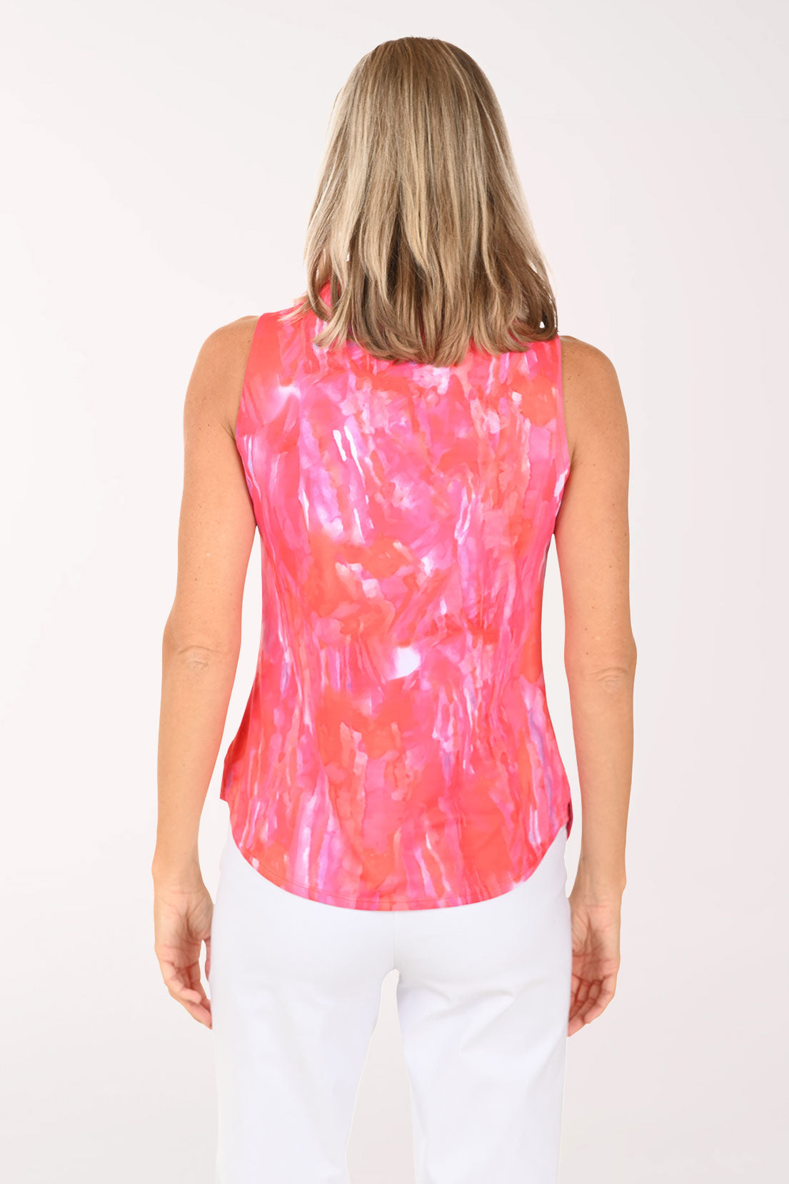 Woman wearing a pink tie-dye sleeveless top on a white background