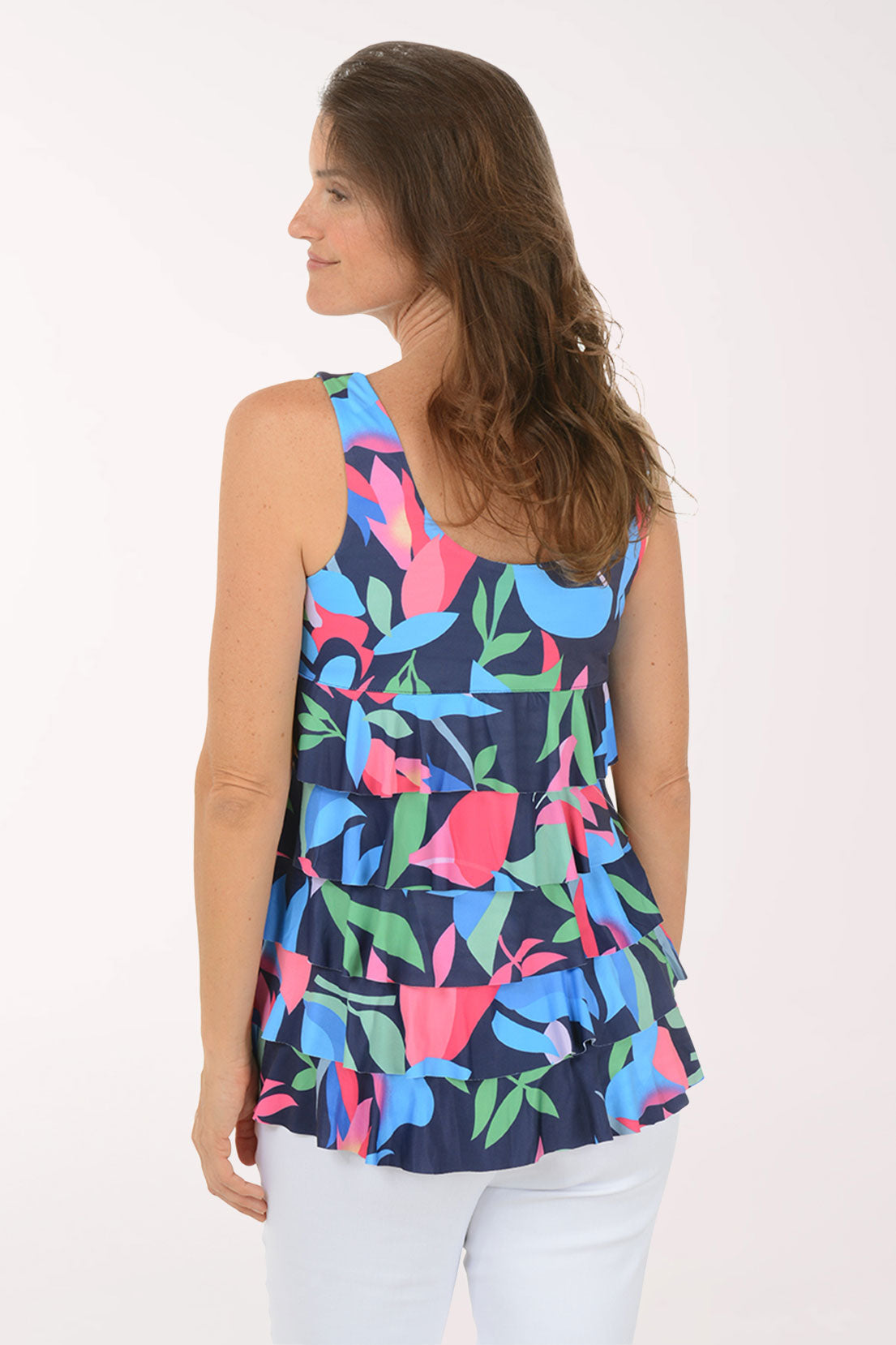 Woman wearing a colorful floral tiered tank top on a white background