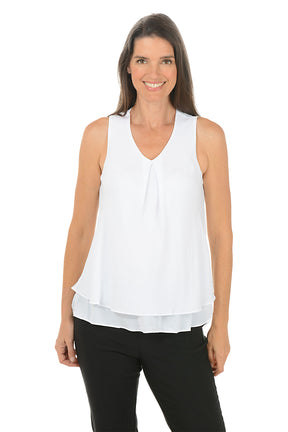 Woman wearing a white sleeveless top and black pants on a white background.