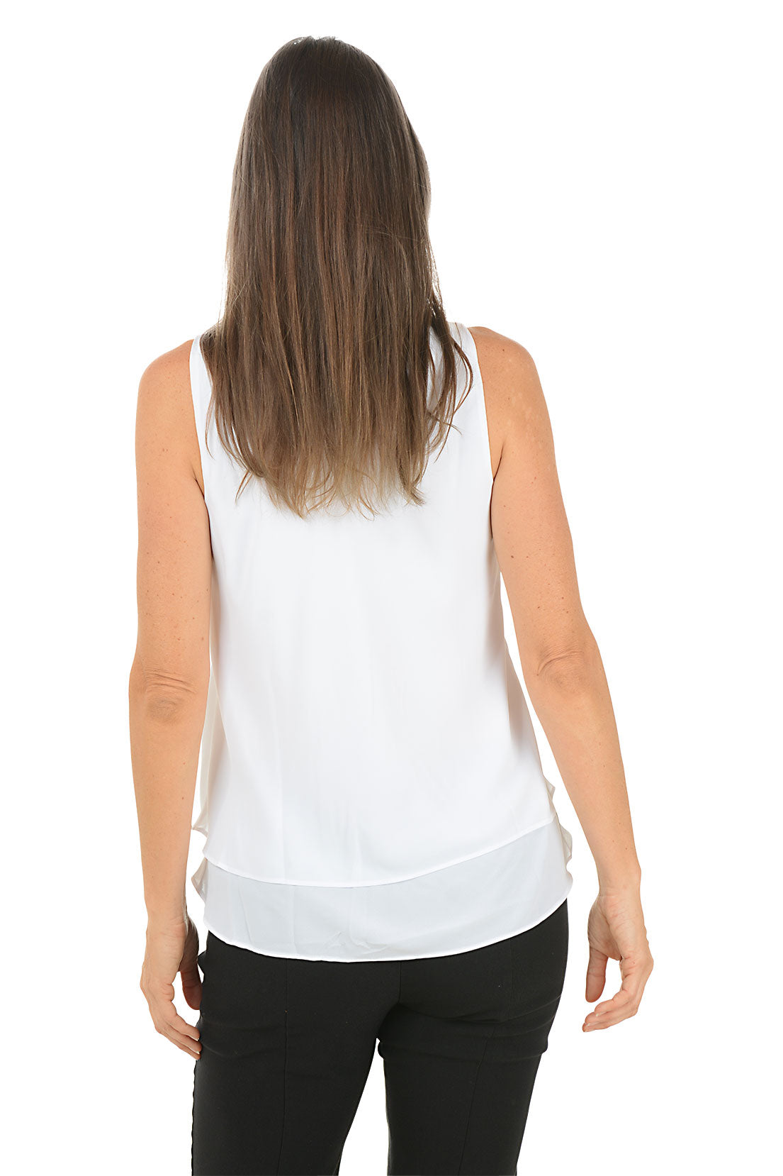 Woman wearing a white sleeveless top and black pants on a white background. Back shot.