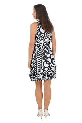 Woman wearing a sleeveless black and white chain link patterned dress on a white background. Back shot.