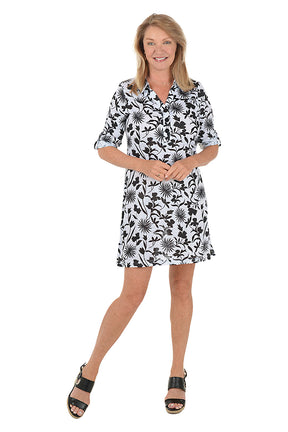 Woman wearing a 3/4 sleeve black and white floral dress on a white background. Second front shot.