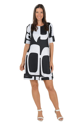 Woman wearing a 3/4 sleeve black and white abstract patterned swing dress on a white background.