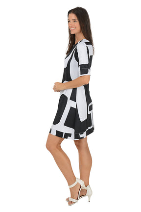 Woman wearing a 3/4 sleeve black and white abstract patterned swing dress on a white background. Side shot.
