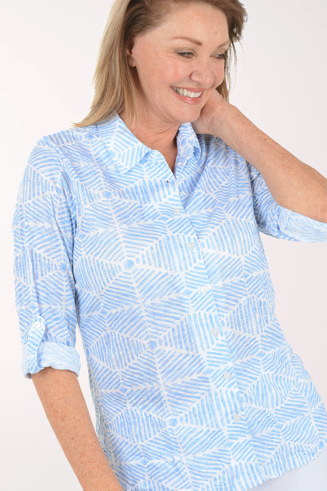 Woman wearing a light blue patterned shirt on a white background