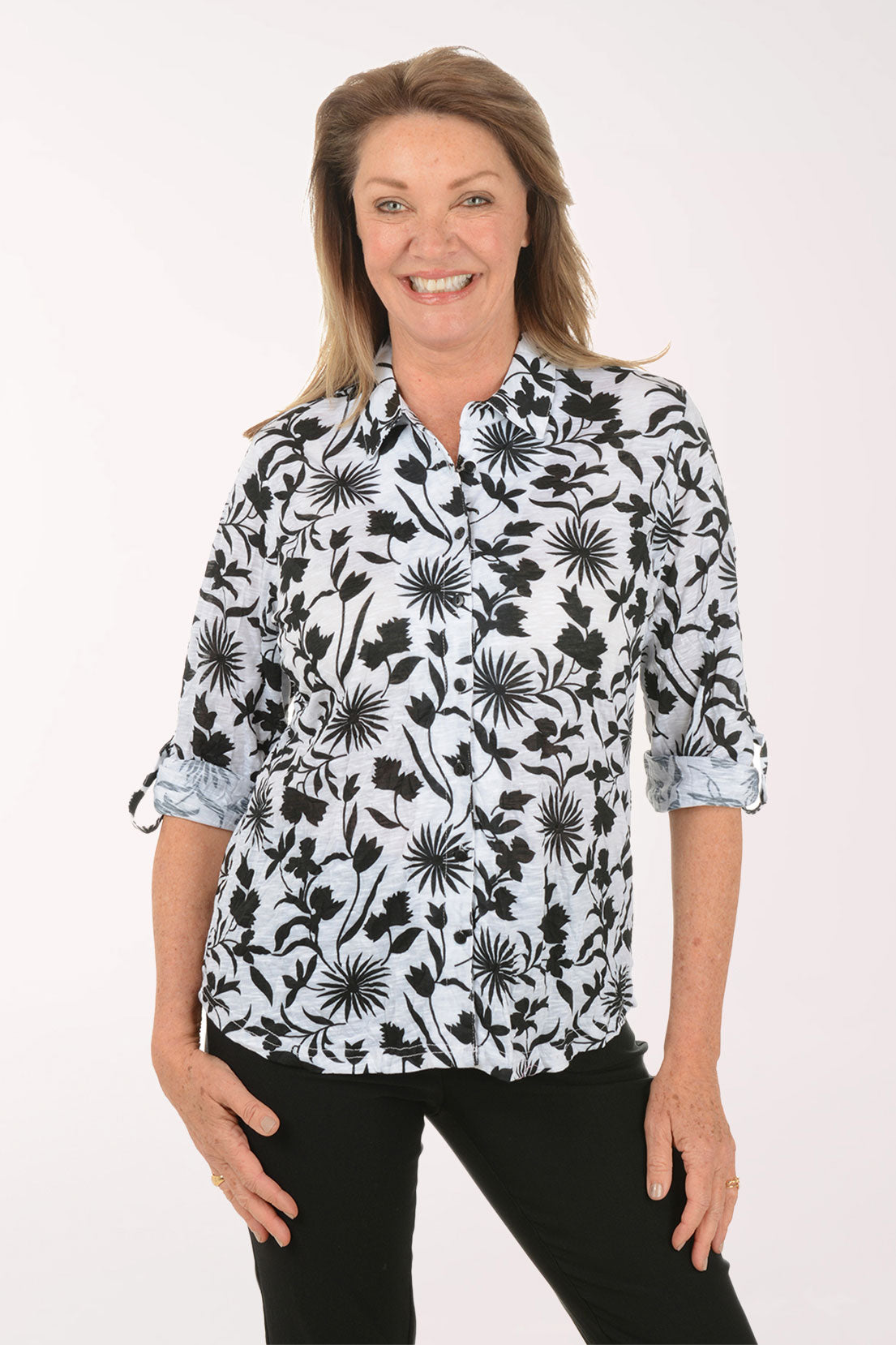 Woman wearing a black floral patterned blouse on a white background