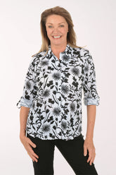 Woman wearing a black floral patterned blouse on a white background