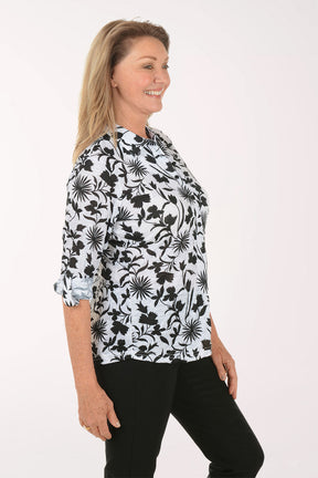 Woman wearing a black floral patterned blouse on a white background