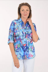 Woman wearing a colorful patterned shirt with 'love' text on a white background