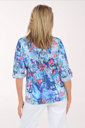 Woman wearing a colorful patterned shirt with 'love' text on a white background