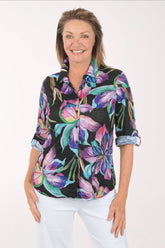 Woman wearing a colorful floral blouse with a white background
