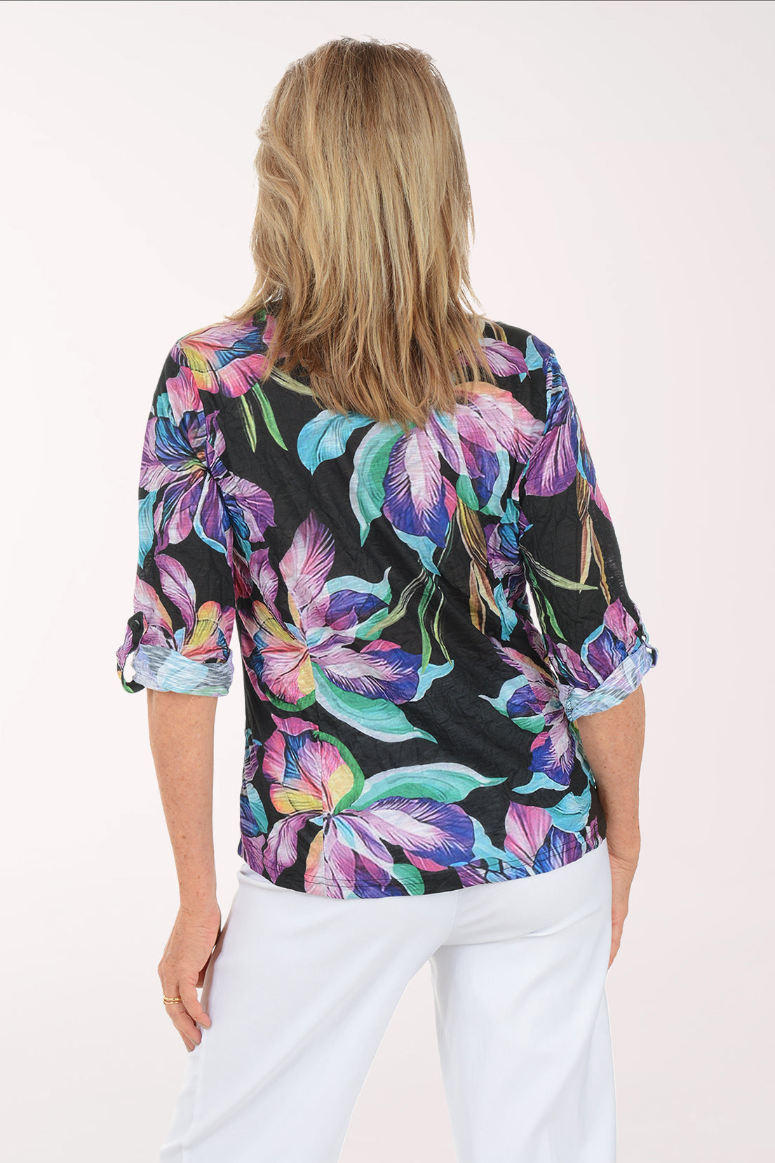 Woman wearing a colorful floral blouse with a white background