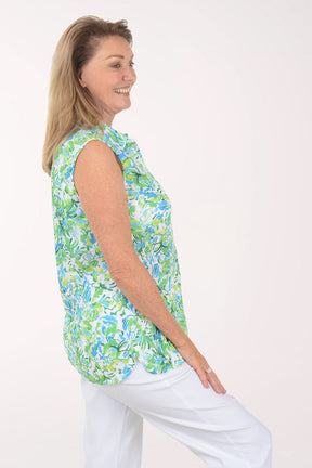 Woman wearing a sleeveless floral blouse with a white background