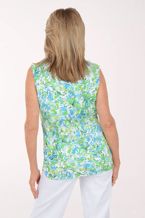 Woman wearing a sleeveless floral blouse with a white background
