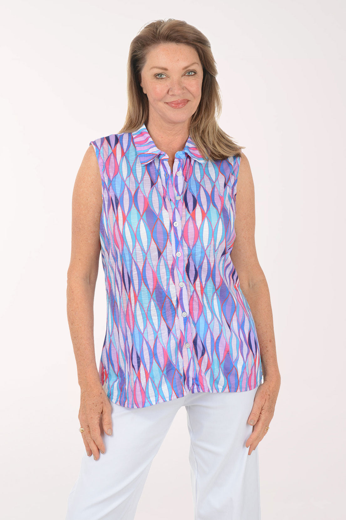 Woman wearing a sleeveless multicolored patterned top on a white background
